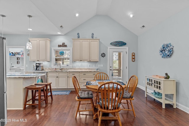 dining space with sink, dark wood-type flooring, and high vaulted ceiling