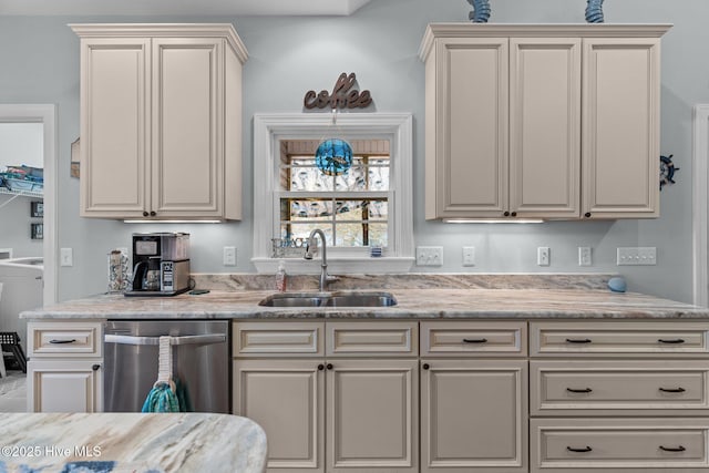 kitchen with light stone countertops, dishwasher, cream cabinets, and sink