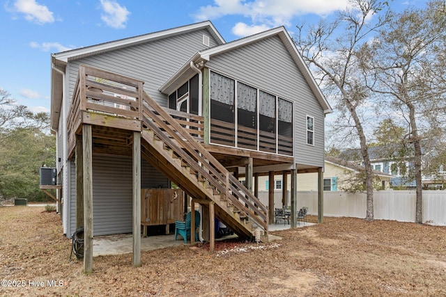 back of property with cooling unit, a sunroom, and a patio