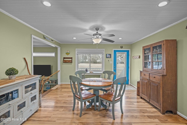 dining area with crown molding and light hardwood / wood-style flooring