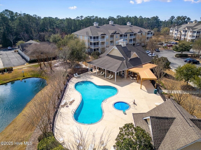 pool featuring a water view and a patio area