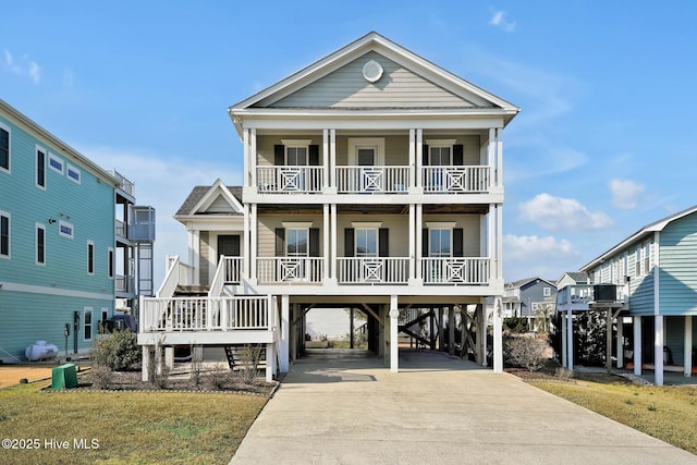 beach home featuring a carport, covered porch, and a front lawn