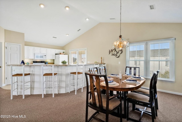 dining area featuring light colored carpet and high vaulted ceiling