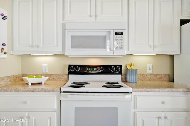 kitchen featuring white cabinetry and white appliances