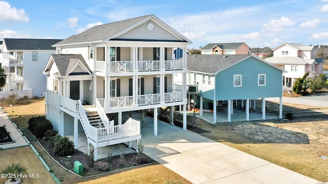 back of property featuring a carport, a balcony, central AC, and covered porch