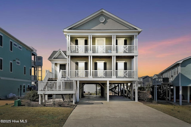 coastal home featuring a carport, a balcony, and covered porch