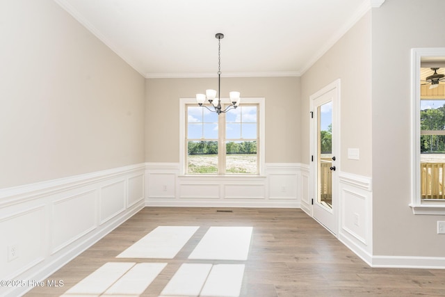 68 Tee Dr, Selma, NC 27576 - unfurnished dining area featuring a wainscoted wall, light wood-style floors, a notable chandelier, a decorative wall, and ornamental molding
