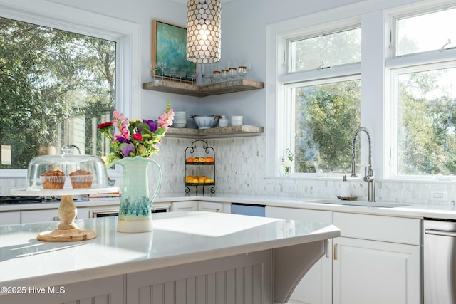 kitchen with a sink, a wealth of natural light, and tasteful backsplash
