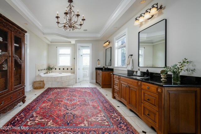 bathroom with a sink, a notable chandelier, crown molding, and a garden tub