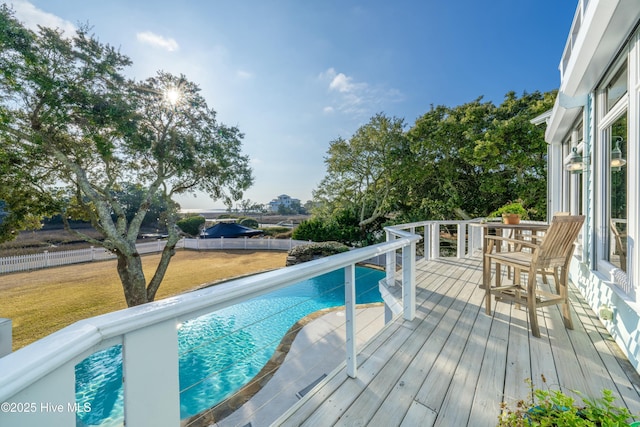 view of swimming pool featuring a deck, a yard, a fenced in pool, and fence