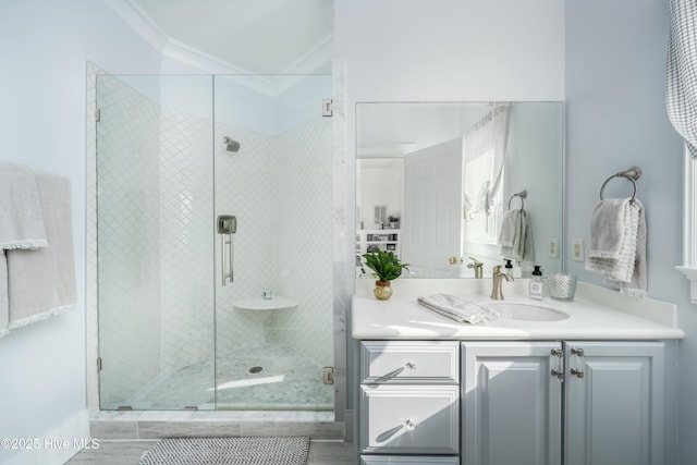 bathroom with a shower stall, crown molding, and vanity