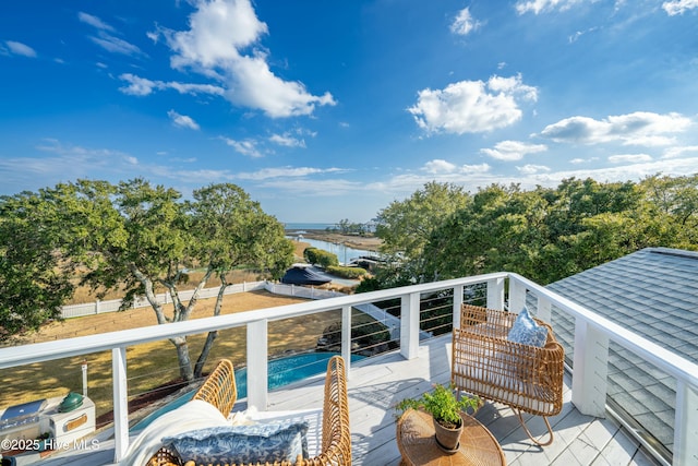 wooden terrace with a water view and fence