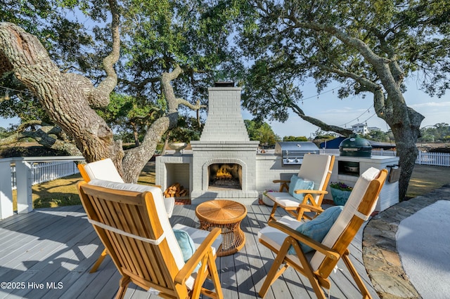 deck with an outdoor living space with a fireplace, fence, exterior kitchen, and area for grilling