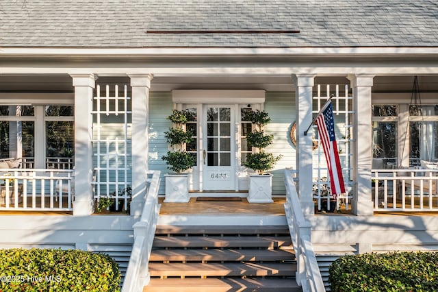 property entrance featuring a shingled roof and covered porch
