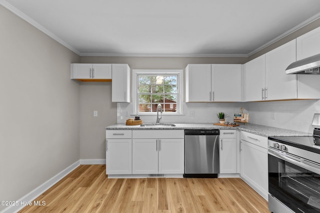 kitchen with sink, tasteful backsplash, appliances with stainless steel finishes, light stone countertops, and white cabinets