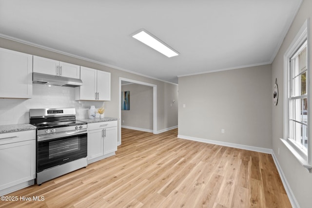 kitchen with stainless steel range with electric cooktop, white cabinetry, light stone countertops, light hardwood / wood-style floors, and backsplash