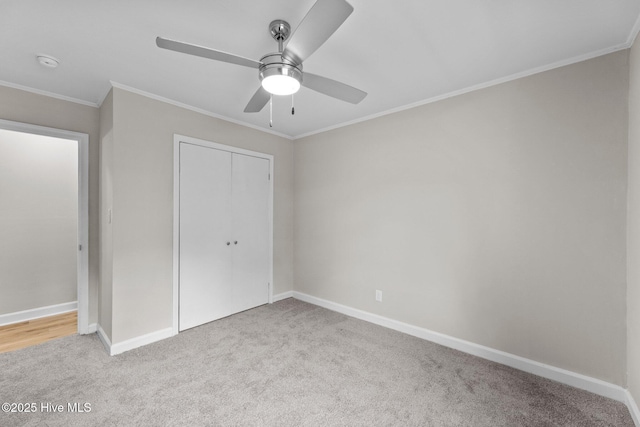 unfurnished bedroom featuring light carpet, ornamental molding, a closet, and ceiling fan