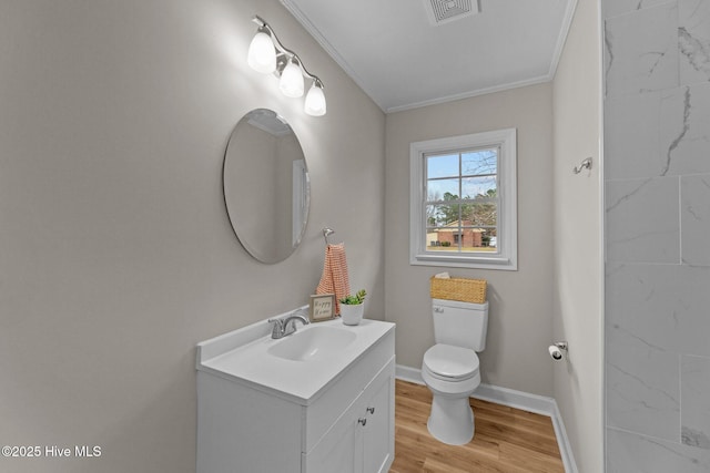 bathroom with vanity, hardwood / wood-style floors, crown molding, and toilet