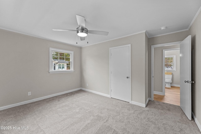 unfurnished bedroom featuring ornamental molding, light colored carpet, and ceiling fan