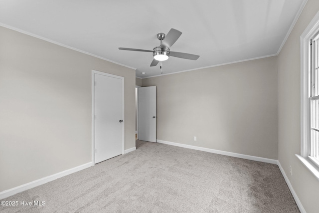 spare room with crown molding, ceiling fan, and light carpet