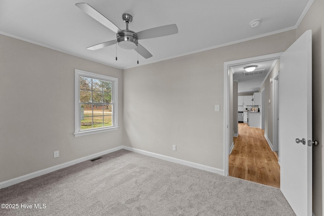 unfurnished bedroom featuring ornamental molding, light carpet, and ceiling fan