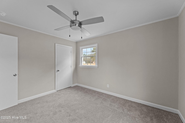 empty room featuring crown molding, ceiling fan, and light carpet