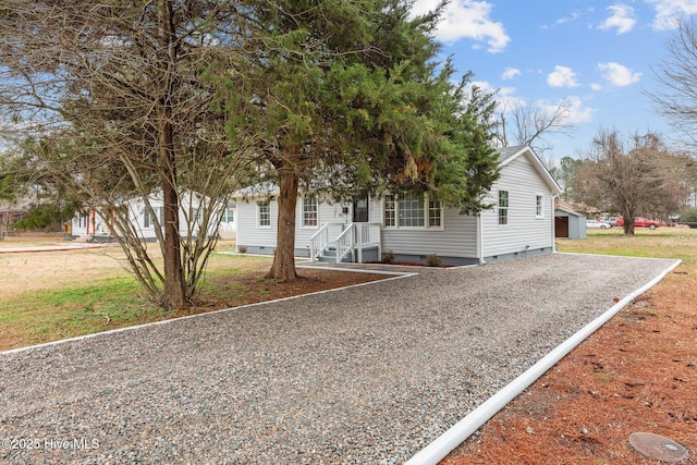 view of property hidden behind natural elements featuring a garage and a front yard