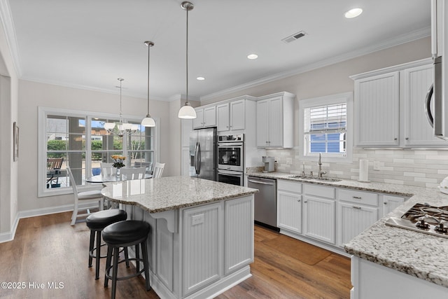 kitchen featuring a center island, appliances with stainless steel finishes, sink, and white cabinets