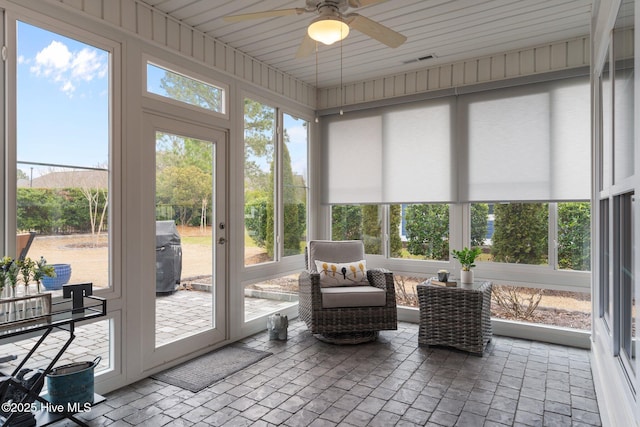 sunroom / solarium featuring ceiling fan