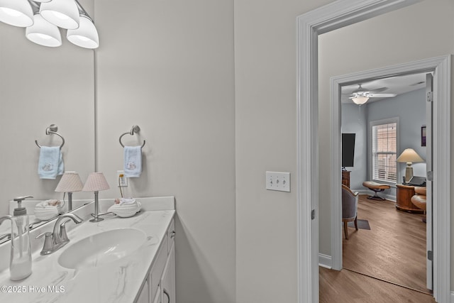 bathroom with hardwood / wood-style flooring, ceiling fan, and vanity