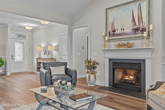 living room featuring hardwood / wood-style flooring, crown molding, and lofted ceiling