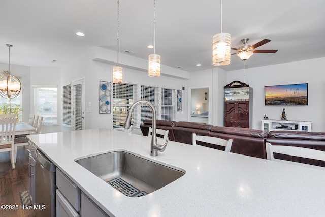 kitchen featuring sink, hanging light fixtures, dark hardwood / wood-style flooring, dishwasher, and ceiling fan with notable chandelier