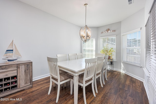 dining room with dark hardwood / wood-style floors and a chandelier