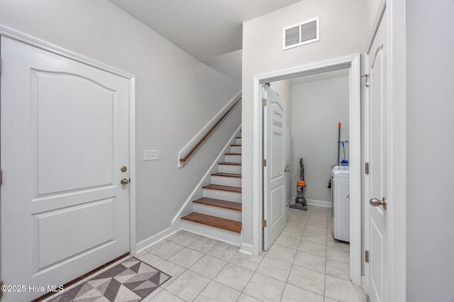 foyer with light tile patterned flooring and washer / dryer