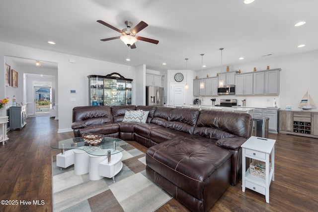 living room featuring dark wood-type flooring, sink, and ceiling fan