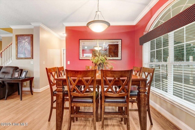 dining area with baseboards, light wood finished floors, and a healthy amount of sunlight