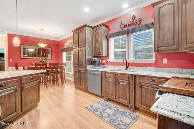 kitchen with crown molding, a sink, stainless steel dishwasher, light wood finished floors, and pendant lighting