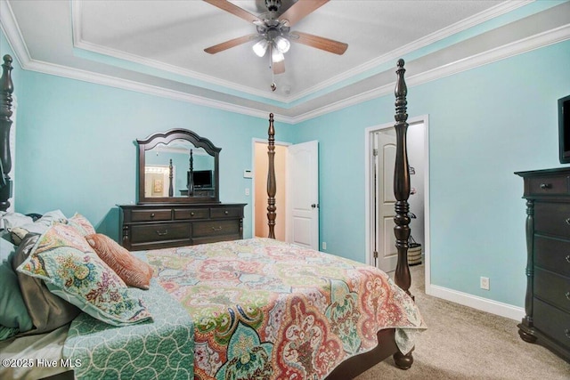 carpeted bedroom featuring baseboards, ceiling fan, a tray ceiling, and crown molding