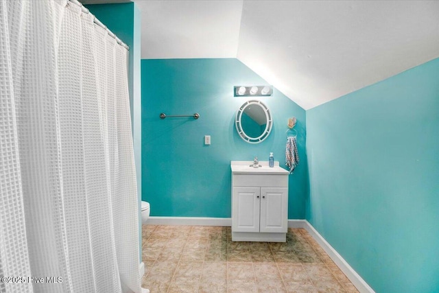 full bathroom with toilet, vaulted ceiling, vanity, and baseboards