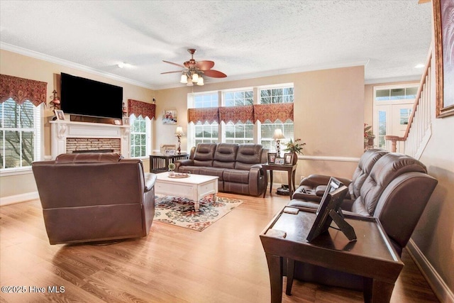 living room featuring a textured ceiling, plenty of natural light, wood finished floors, and crown molding