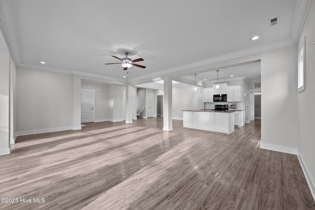 unfurnished living room featuring light wood-style flooring, crown molding, baseboards, and ceiling fan