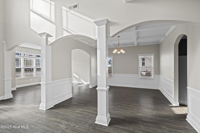 interior space with beamed ceiling, coffered ceiling, a wealth of natural light, and dark hardwood / wood-style floors