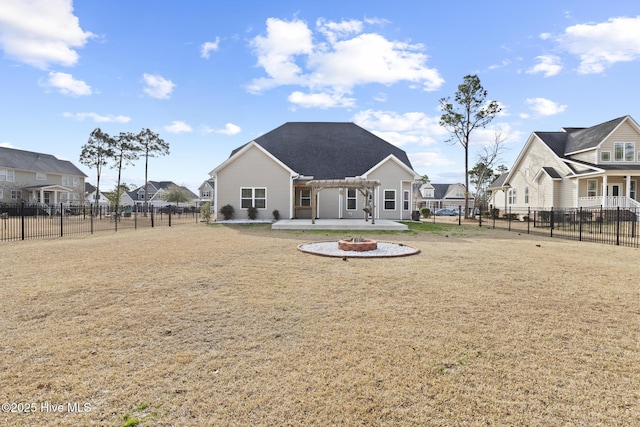 back of house featuring a pergola, a patio area, a lawn, and an outdoor fire pit