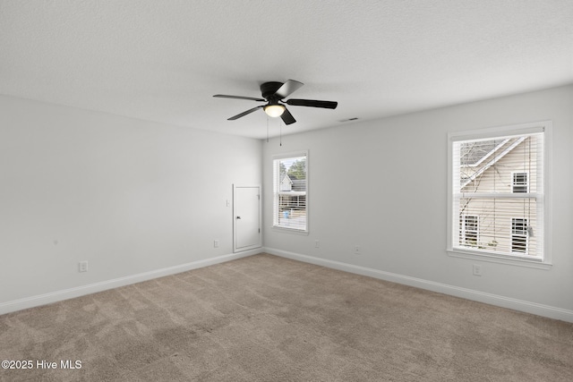 carpeted spare room with ceiling fan and a textured ceiling