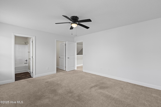 unfurnished bedroom featuring ensuite bath, carpet floors, and ceiling fan