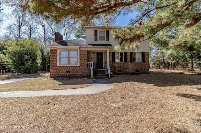 traditional-style home featuring brick siding, crawl space, and a chimney