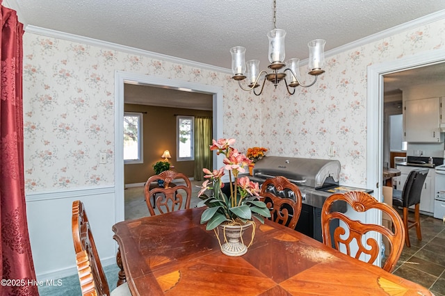 dining space with crown molding, a textured ceiling, an inviting chandelier, and wallpapered walls