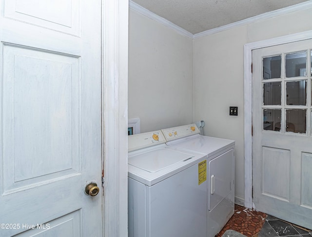 clothes washing area featuring ornamental molding, washing machine and dryer, and laundry area