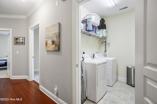 laundry area with crown molding and separate washer and dryer