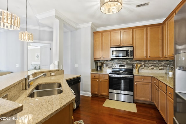 kitchen featuring light stone counters, appliances with stainless steel finishes, sink, and pendant lighting